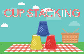 Plastic cups on picnic blanket. Text reads cup stacking.